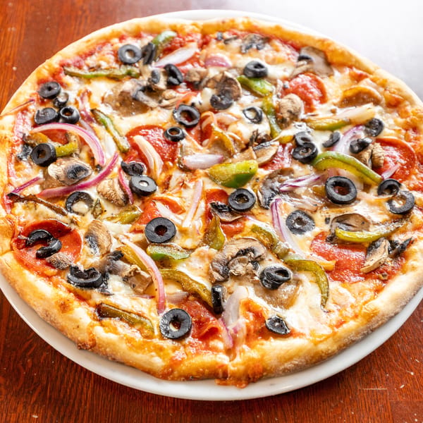 A whole pizza with pepperoni, mushrooms, green peppers, red onions, and black olives.